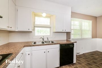 Blue Springs house for rent - A kitchen with white cabinets and a granite countertop.