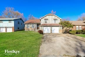 Kansas City house for rent - a white and brick house with a driveway and a blue sky