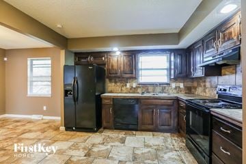 Kansas City house for rent - a kitchen with black appliances and wooden cabinets