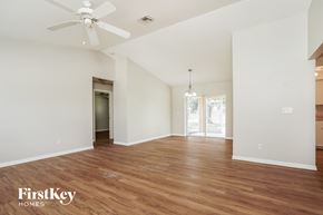 Cape Coral house for rent - a living room with white walls and wood flooring and a ceiling fan