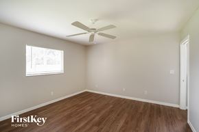 Cape Coral house for rent - a bedroom with hardwood flooring and a ceiling fan