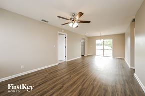 Cape Coral house for rent - an empty living room with wood floors and a ceiling fan