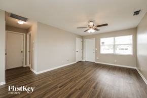 Cape Coral house for rent - an empty living room with wood floors and a ceiling fan