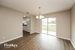 Cape Coral house for rent - an empty living room with a sliding glass door to the kitchen