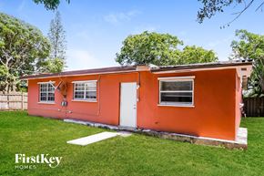 Boynton Beach house for rent - a small house with an orange exterior and a lawn