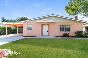 Boynton Beach house for rent - A pink house with a white door and windows is for sale.