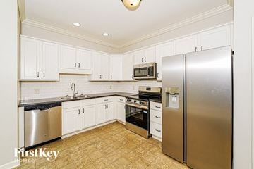 Gardendale house for rent - A kitchen with white cabinets and a stainless steel refrigerator.