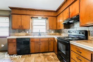 Lee's Summit house for rent - a kitchen with black appliances and wooden cabinets