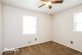Lee's Summit house for rent - a bedroom with two windows and a ceiling fan