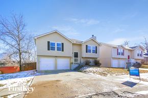 Independence house for rent - a beige house with white garage doors and snow on the ground