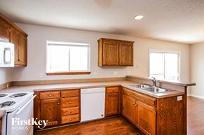 Independence house for rent - a kitchen with wooden cabinets and white appliances and a sink