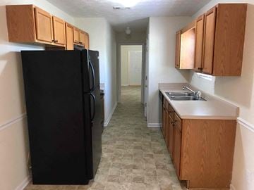 Locust Grove house for rent - a kitchen with a black refrigerator and wooden cabinets