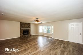 Newnan house for rent - A spacious room with a fireplace and wood flooring.