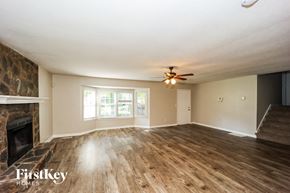 Newnan house for rent - A room with a fireplace and wood flooring.