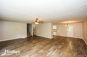 Newnan house for rent - A spacious room with wooden flooring and a ceiling fan.