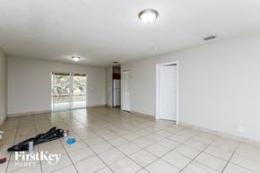 Deerfield Beach house for rent - the living room is spacious and clean with white tile and a door to the backyard