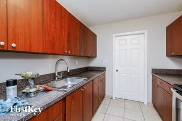 Deerfield Beach house for rent - a kitchen with wooden cabinets and a sink and a white door