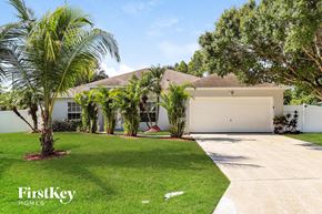 Port St. Lucie house for rent - A white house with a palm tree in front of it.