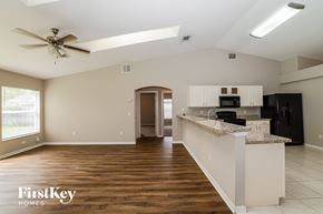 Port St. Lucie house for rent - A spacious kitchen and living room with a wood floor and a ceiling fan.
