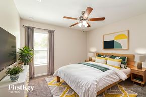 Port St. Lucie house for rent - A bedroom with a bed, a ceiling fan, and a painting on the wall.