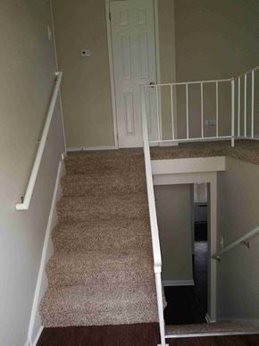 Glenwood house for rent - a set of stairs with carpet in a home with a white door