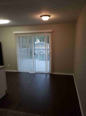 Glenwood house for rent - an empty living room with a sliding glass door to a patio
