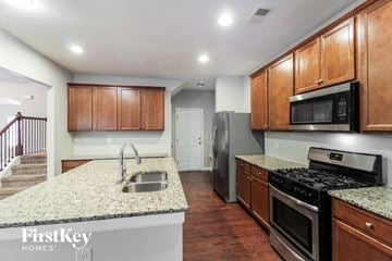 Mcdonough house for rent - A kitchen with wooden cabinets and a granite countertop.