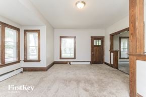 Aurora house for rent - an empty living room with white walls and wooden doors and windows