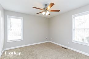 Fuquay Varina house for rent - a bedroom with a ceiling fan and two windows