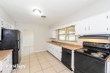 Winter Garden house for rent - a kitchen with white cabinets and black appliances