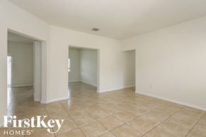 Homestead house for rent - A spacious room with tiled flooring and white walls, part of a property by FirstKey Homes.