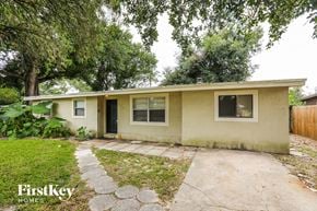 Altamonte Springs house for rent - a small tan house with a sidewalk and trees