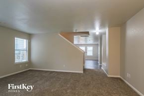 Houston house for rent - A spacious room with a carpeted floor and a staircase leading to another room.