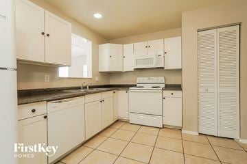 Cape Coral house for rent - a white kitchen with white appliances and white cabinets