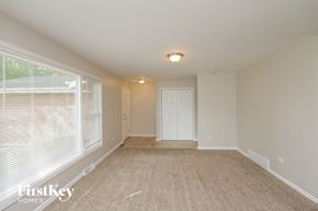 Glenwood house for rent - a spacious living room with a large window and carpeting
