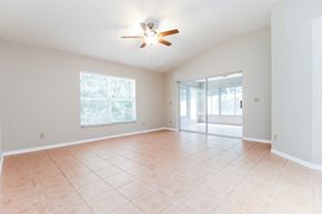 Tarpon Springs house for rent - an empty living room with a ceiling fan and a tiled floor