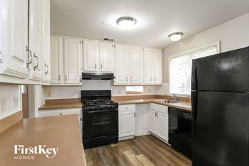 Florissant house for rent - A kitchen with black appliances and white cabinets.