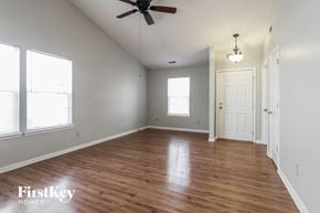 Indianapolis house for rent - an empty living room with wood floors and a ceiling fan