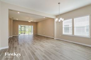 St. Augustine house for rent - A spacious room with wooden flooring and a chandelier hanging from the ceiling.