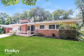 Florissant house for rent - A house with a red brick chimney and a white porch.