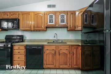 Florissant house for rent - A kitchen with wooden cabinets and a stainless steel refrigerator.
