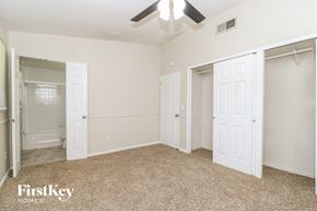 Florissant house for rent - A bedroom with a carpeted floor and a ceiling fan.