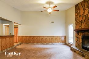 Acworth house for rent - A living room with a fireplace and a ceiling fan.