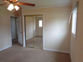 Park Forest house for rent - an empty bedroom with a mirror and a ceiling fan