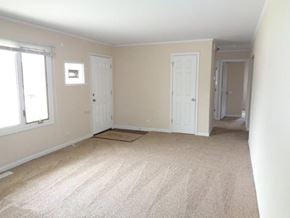 Park Forest house for rent - an empty living room with two doors and a carpet