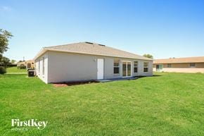 Poinciana house for rent - a small white house with a yard and grass