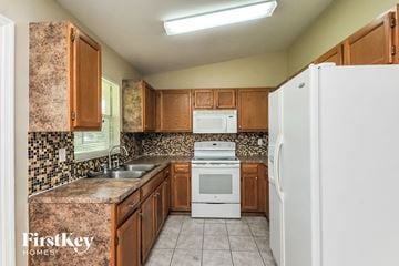 Winter Haven house for rent - a kitchen with white appliances and wooden cabinets