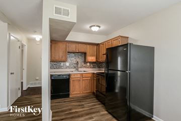 Ballwin house for rent - a kitchen with black appliances and wooden cabinets and a black refrigerator