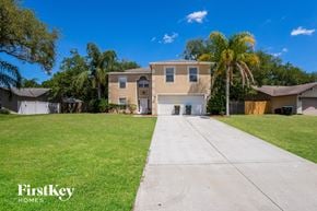 Palm Bay house for rent - a beige house with a lawn and palm tree