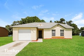 La Belle house for rent - a beige house with a garage and a green lawn